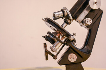 An old microscope, close up. Vintage microscope on the table.