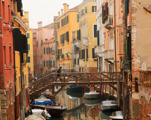 Small wooden bridge over narrow canal and typical colorful houses in Venice, Italy. vintage postcard style