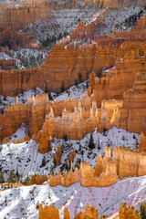 close up telephoto zoom photo of bryce canyon national park hoodoos lit by sun illuminating reds, oranges, pinks, and whites.