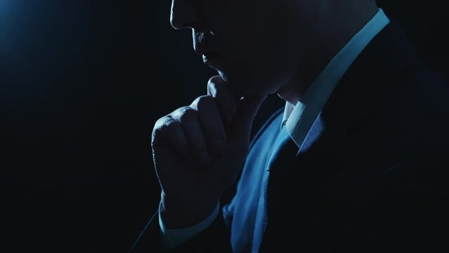 顎に手を当てて考え事をしているビジネスマンの男性