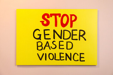 Yellow card with text Stop Gender Based Violence on pink background, top view