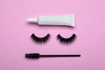 Flat lay composition with fake eyelashes on pink background