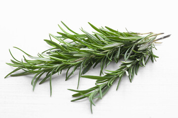 Fresh green rosemary twigs on white wooden table, closeup