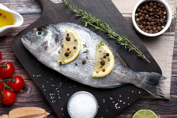 Fresh dorado fish and ingredients on wooden table, flat lay