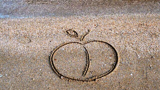 Apple drawing on sand. Drawing on sand.