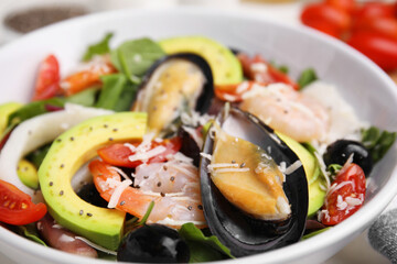 Bowl of delicious salad with seafood, closeup view