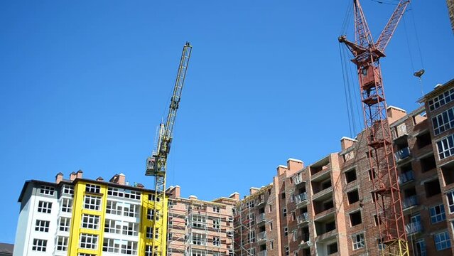 Construction cranes over houses. Shooting of construction