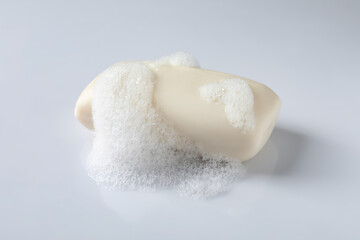 Soap with fluffy foam on white background