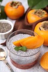 Delicious dessert with persimmon and chia seeds on table
