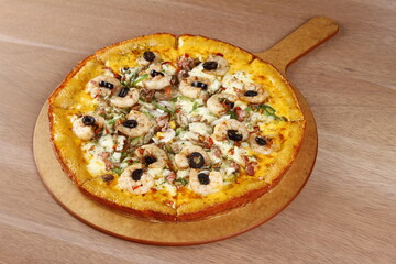 Cheesy seafood pizza with shrimp, bacon, olives, bell peppers, tomato