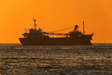 Obraz premium 明石海峡で見た夕焼けに染まる海と貨物船のコラボ情景＠兵庫
