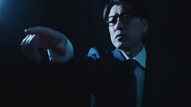 指を差して偉そうに指示をしているビジネスマンのミドル男性