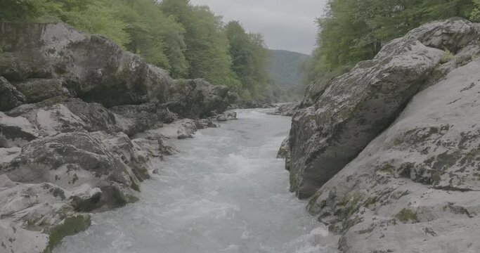 Aerial view of Mountain river and road. Flying over a mountain gorge. Slow motion 120 fps, ProRes 422, 10 bit ungraded DJI D-LOG video