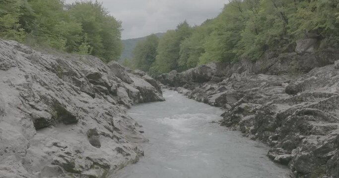 Aerial view of Mountain river and road. Flying over a mountain gorge. Slow motion 120 fps, ProRes 422, 10 bit ungraded DJI D-LOG video