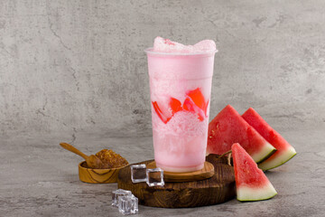 Boba or tapioca pearls is taiwan bubble milk tea in plastic cup with watermelon flavor on texture ...