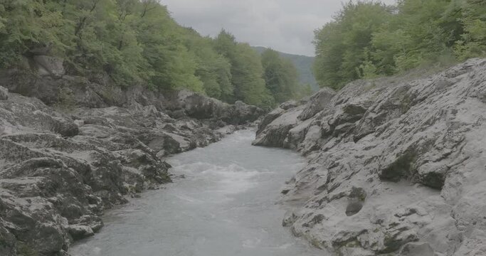 Aerial view of Mountain river and road. Flying over a mountain gorge. Slow motion 120 fps, ProRes 422, 10 bit ungraded DJI D-LOG video