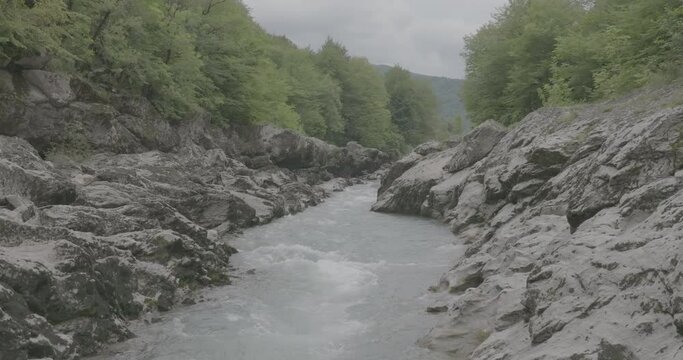 Aerial view of Mountain river and road. Flying over a mountain gorge. Slow motion 120 fps, ProRes 422, 10 bit ungraded DJI D-LOG video
