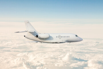 Fototapeta na wymiar White modern luxury business jet flies in the air above the clouds