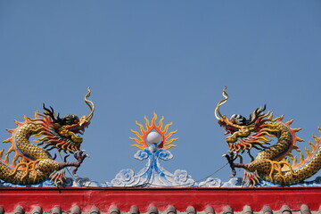 Dragons on roof of Chinesse shrine against blue sky