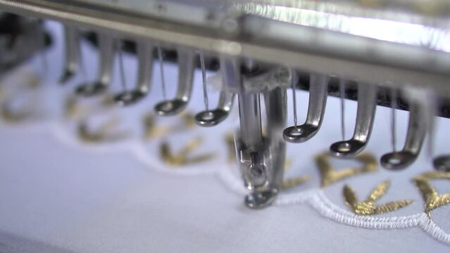 Embroidery machine creating textile patterns on cloth. Embroidery machine in Slow motion video. Sewing machine or embroidery machine in textile industry. Slow motion.