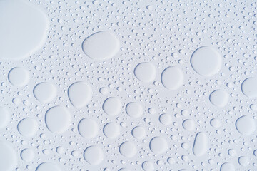 small and large drops of water on a white background texture, macro. Freshness or morning dew.