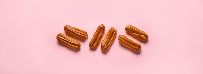 Sweet tasty eclairs on pink background, top view