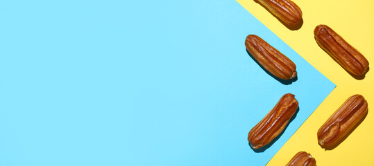 Sweet tasty eclairs on color background with space for text, top view