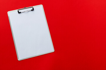 Clipboard with a paper on red background