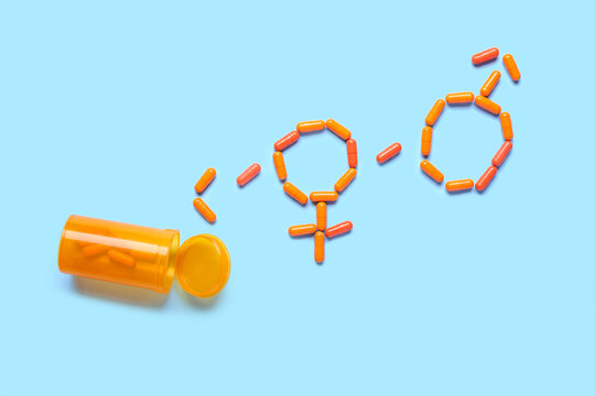 Gender symbols made of pills on blue background. Sex concept