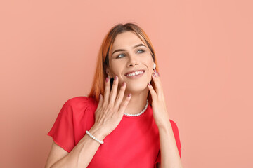 Young transgender woman with beautiful manicure on pink background