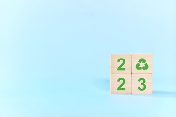 Ecological and sustainable year 2023 concept. Wooden blocks with recycling symbol.