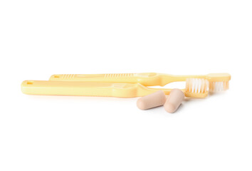 Toothbrushes and ear plugs on white background