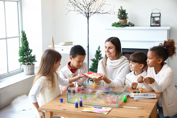 Little children with teacher during master class in Ebru painting on Christmas eve