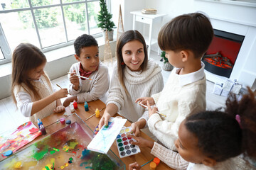 Little children with teacher during master class in Ebru painting on Christmas eve