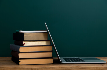 Laptop and book in front of the blackboard