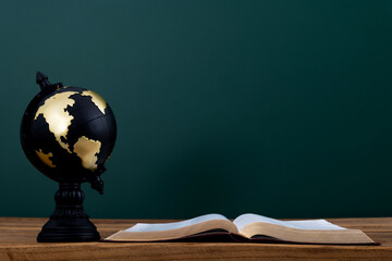 Globe and book in front of the blackboard