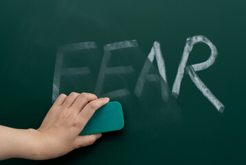 Erasing the word fear on chalkboard