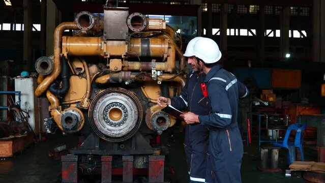 Engineer in the process of inspecting train engines Keep the machine ready for use in the train station. Engineers wear safety clothing and helmets to work safely as standard.
