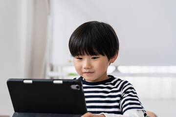 タブレットPCを見る日本人小学生の男の子