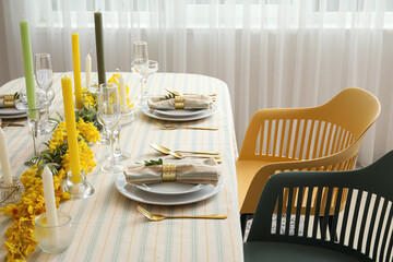Dining table with beautiful setting and floral decor in light room