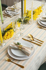 Beautiful dinnerware, candles and floral decor on served table