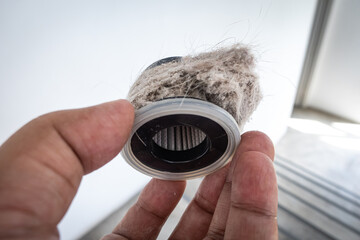Household vacuum cleaner filter clogging up with dust, mite, hair, and animal fur after an...