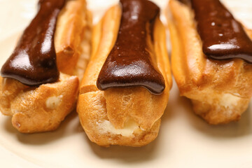 Plate of sweet chocolate eclairs, closeup