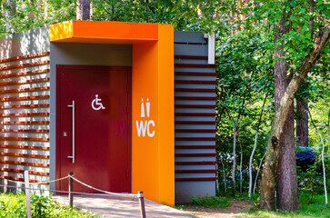 Modern public toilet in city park. Toilet with icons: disabled person, female, male. toilet sign, WC