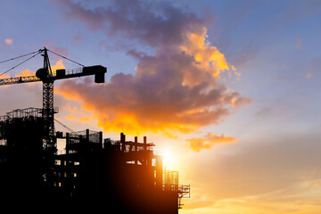 Silhouettes of building construction site with clipping path and construction cranes with blurred sunset background and copy space