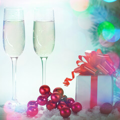 two glasses with champagne, and boxes with gifts on Christmas b