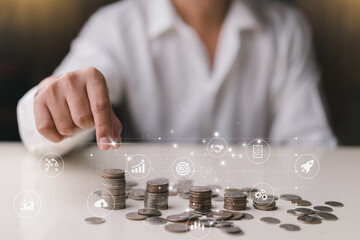 Businessman holding coins putting on Stacking coins, coins, graph on table. plan revenue and expenses, target success growth, finance profit planning 2023 concept.
