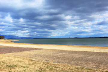冬の雲におおわれた薄日の射す琵琶湖岸の風景