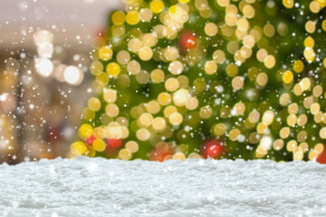 Empty white snow with blur Christmas tree with bokeh light background