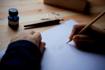 Children's hand and drawing on white paper with a simple pencil.